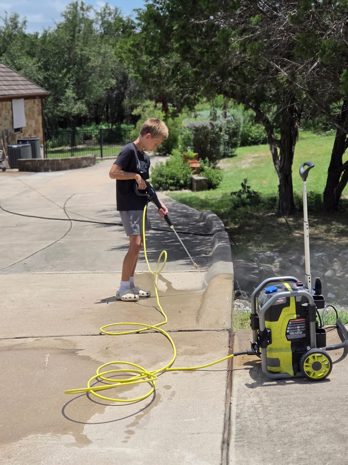 D1 Outdoor Services washing the edge of a driveway by the pressure washer